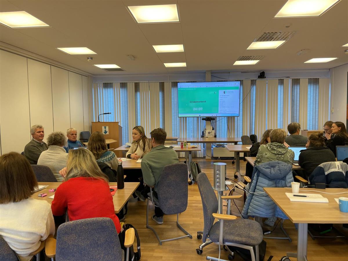 Forsamling ser mot skjerm - Klikk for stort bilete